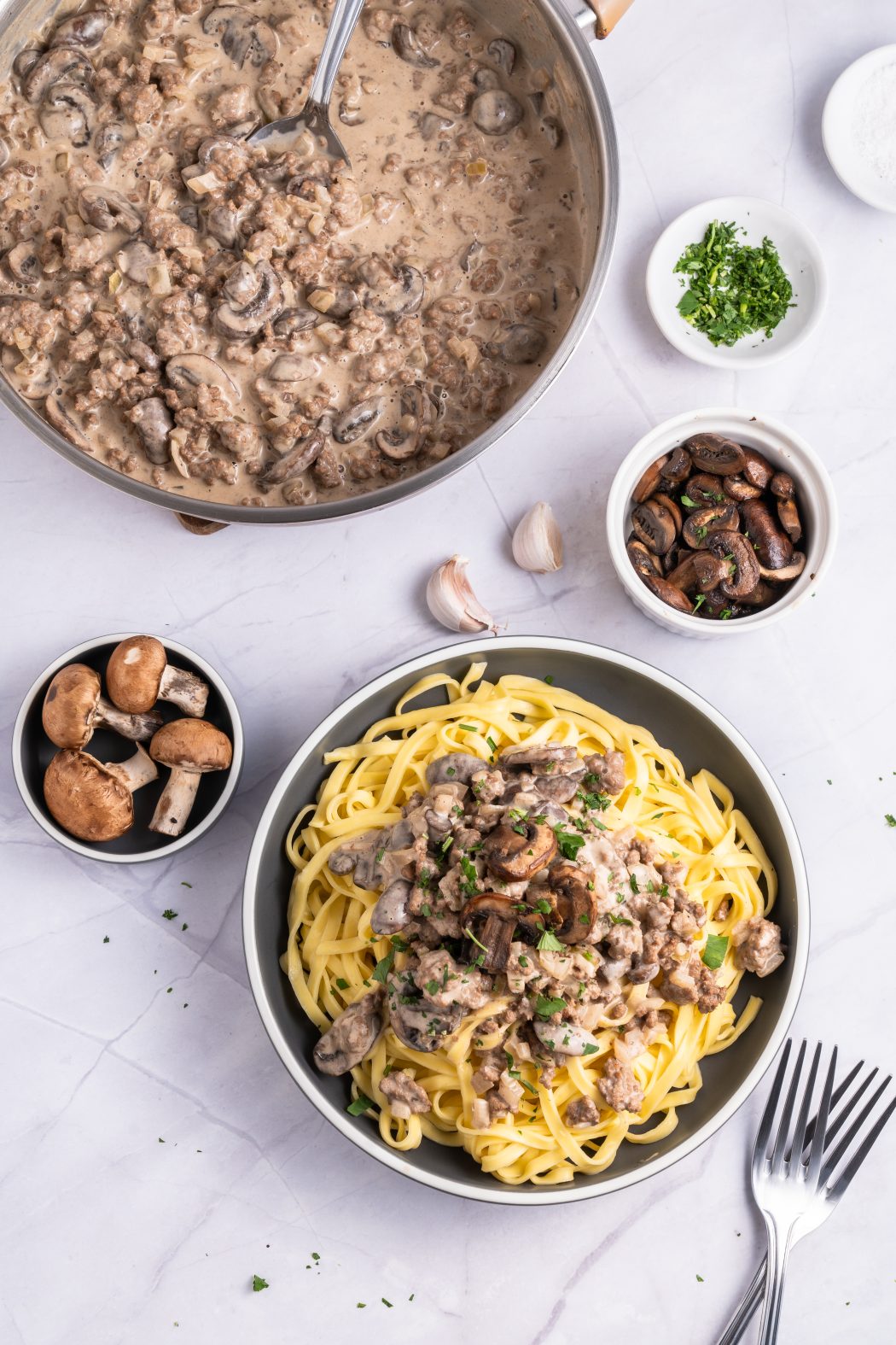 ground beef stroganoff with bowls of mushrooms and garlic near