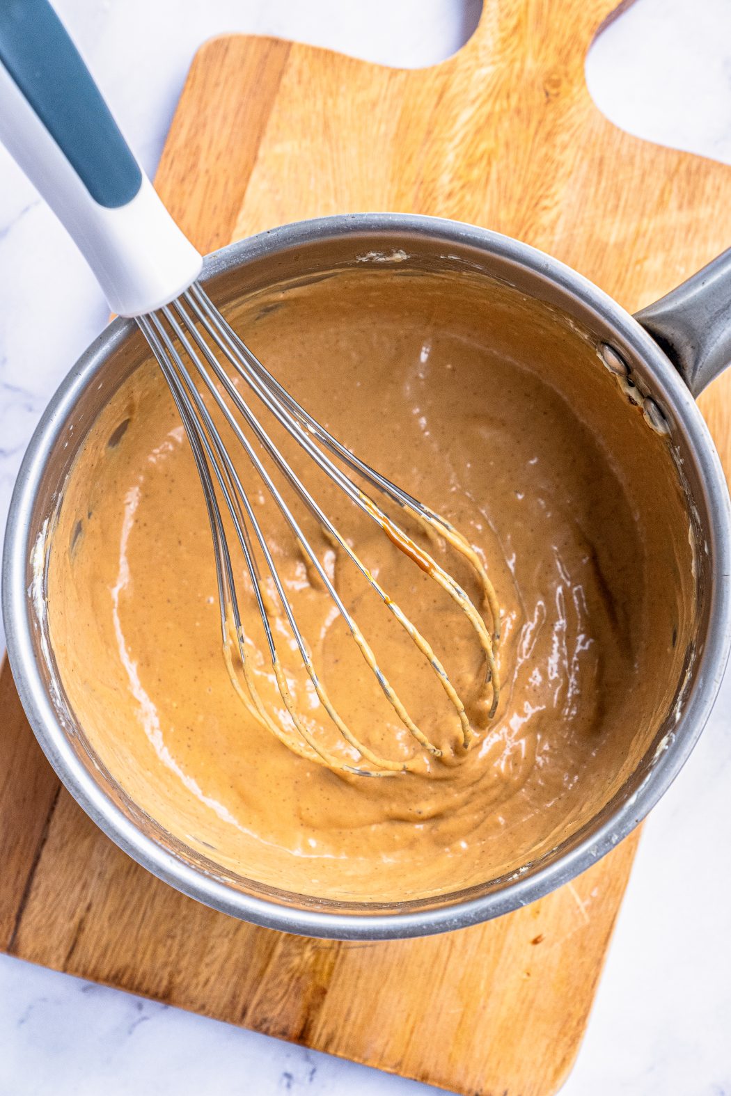 melted caramel mixed with a whisk in a pot