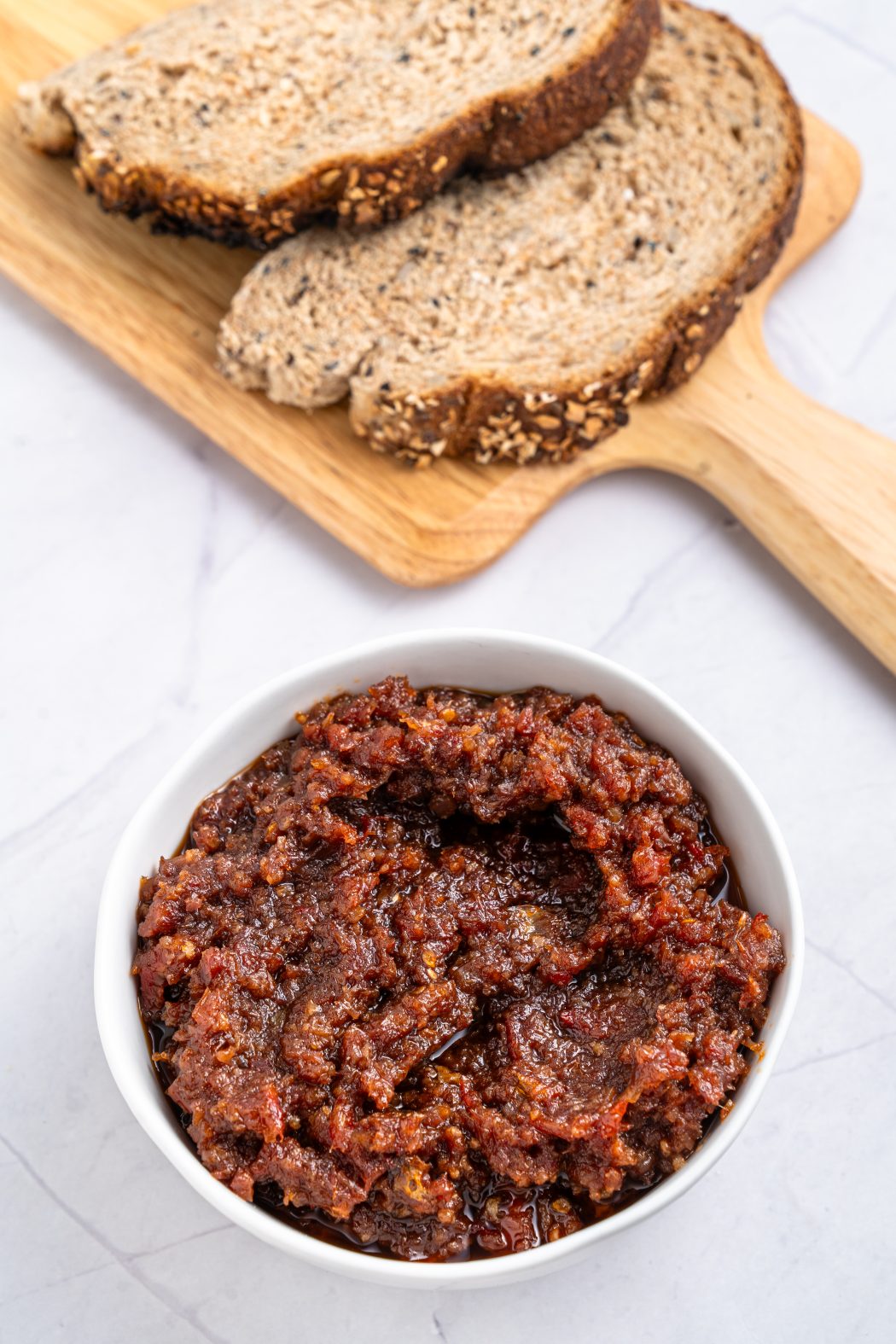 tomato bacon jam in a bowl near wheat bread