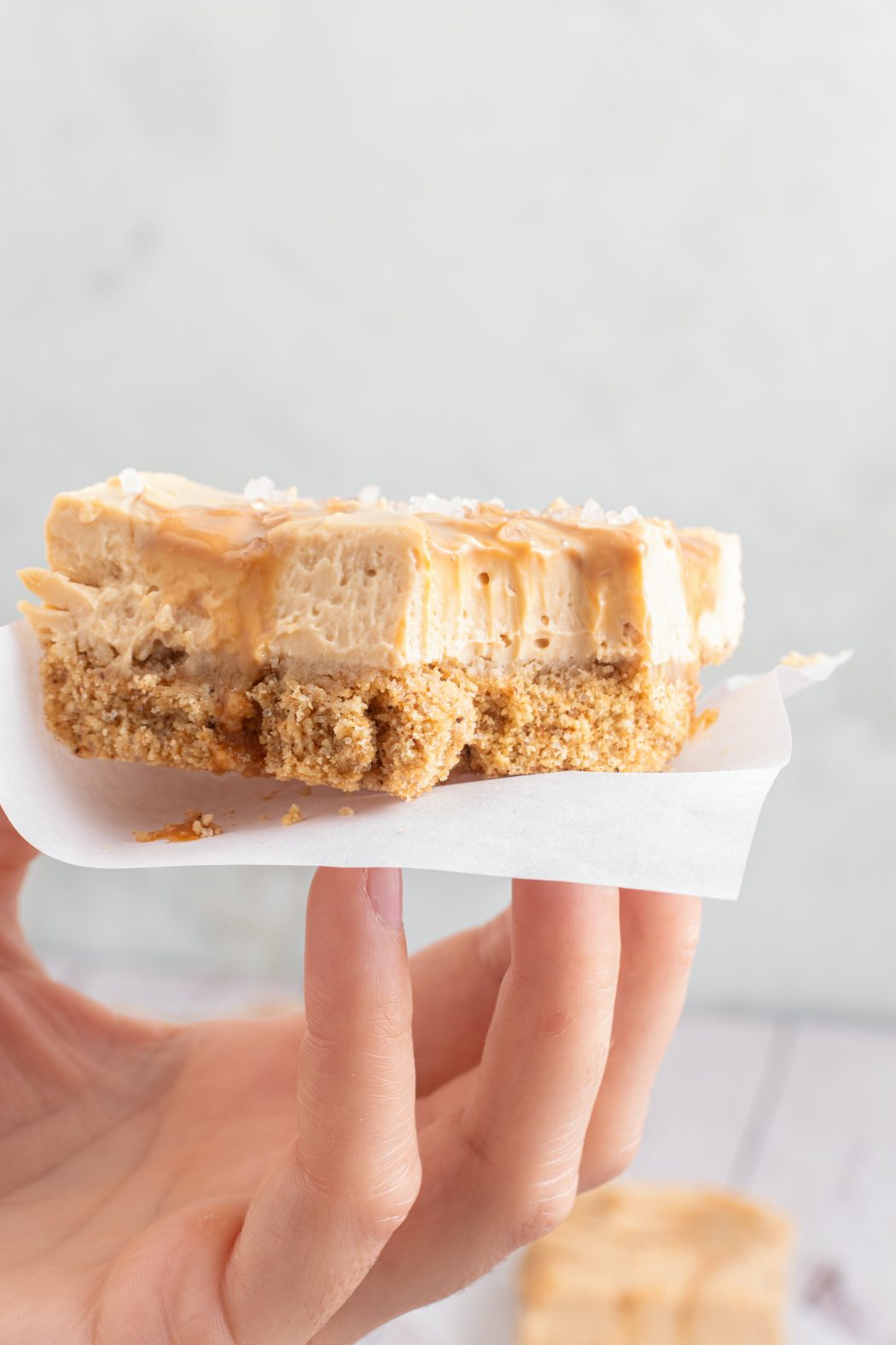 a bite out of a dulce de leche cheesecake bar