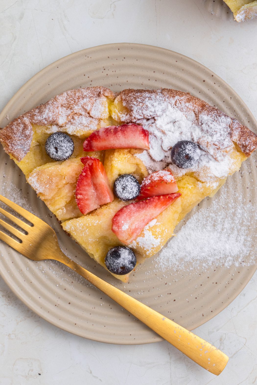 dutch baby pancake on a plate with a gold fork