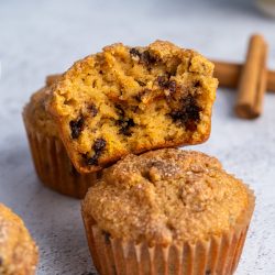 Two almond flour pumpkin muffins with one broken apart