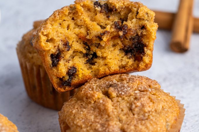 Two almond flour pumpkin muffins with one broken apart