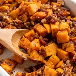 Wooden spoon scooping out sweet potato casserole