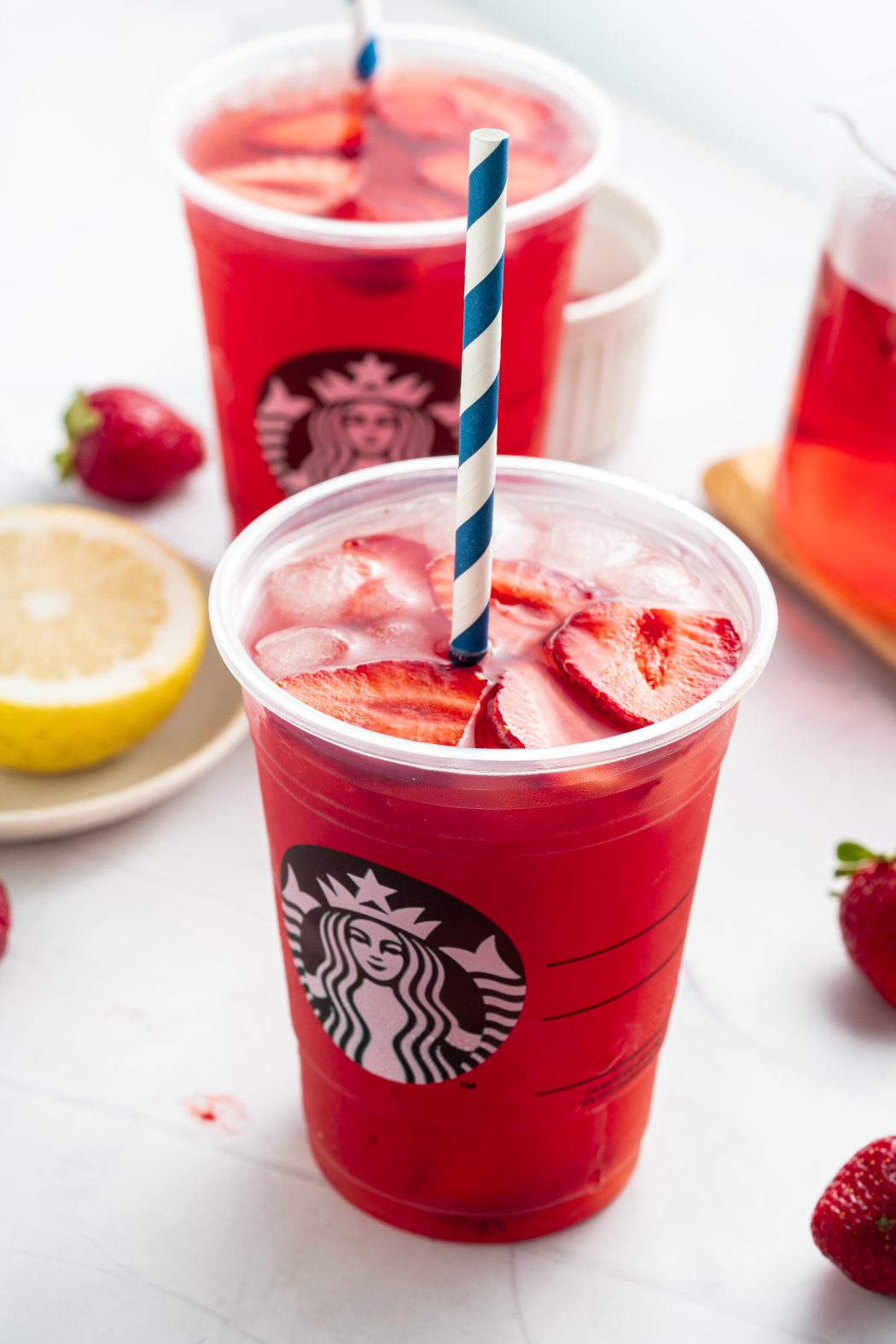 Two Strawberry Açaí Starbucks Refreshers with straws