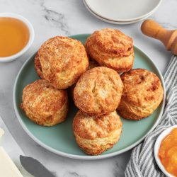 Plate of air fryer biscuits with butter and honey to the sides of the plate