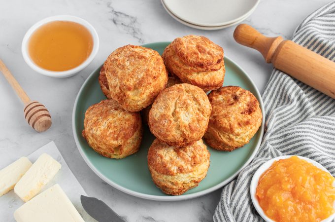 Plate of air fryer biscuits with butter and honey to the sides of the plate